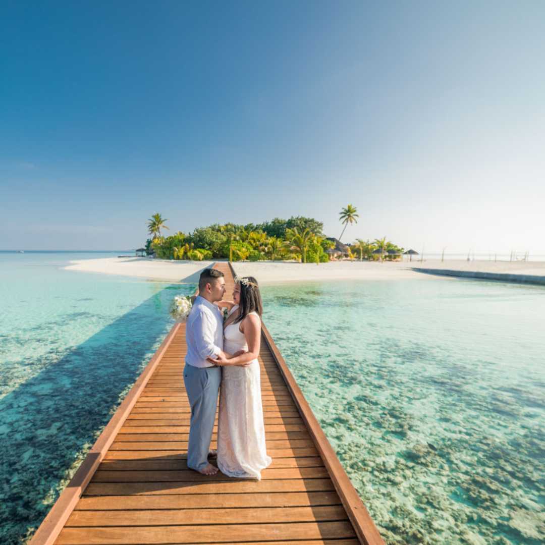 A crystal clear view of Maldives villas on crystal-clear turquoise waters surrounded by coral reefs.